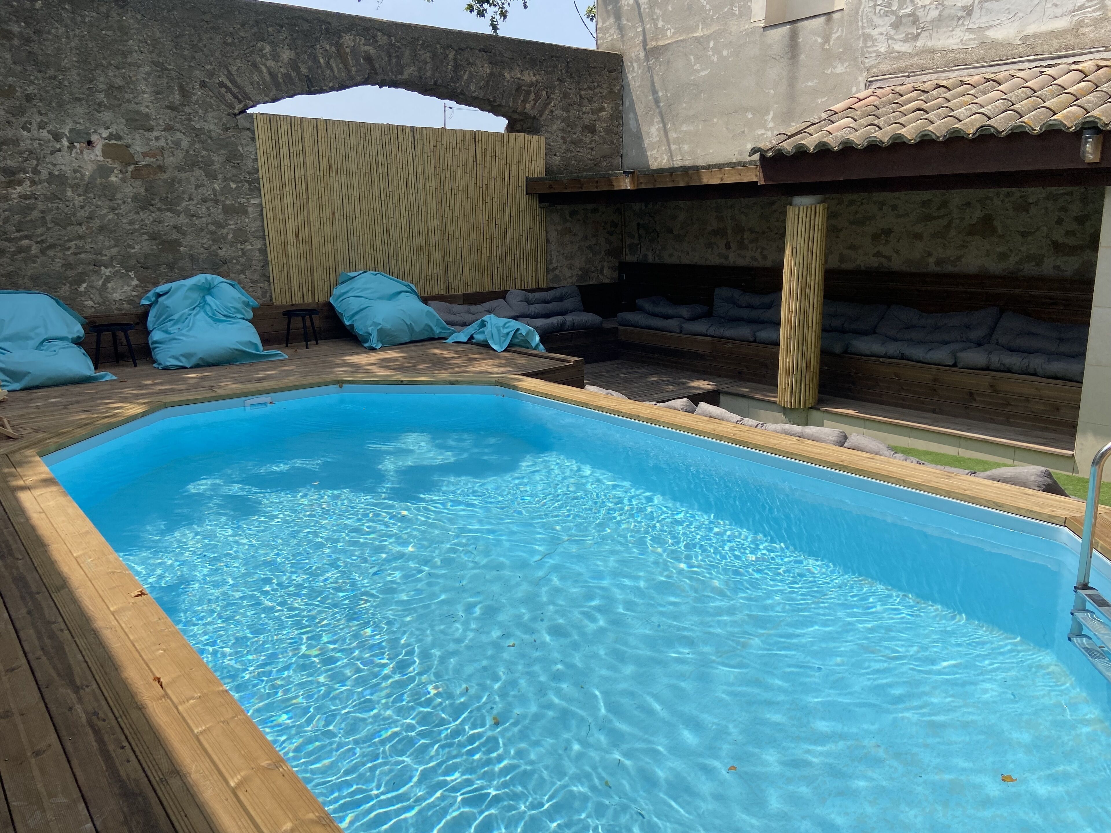 Une piscine rectangulaire entourée d’une terrasse en bois.