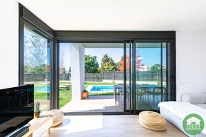 A modern living room with a large sliding glass door leading to an outdoor patio area.