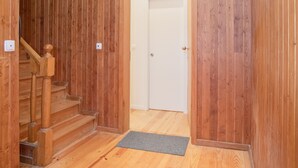 A wooden interior hallway with a staircase leading to a white door. - Liiiving - Oasis Retreat Apartment (Porto)