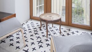 A balcony with a wooden door, a wicker chair, and a small table. - Liiiving - Oasis Retreat Apartment (Porto)
