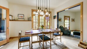 Un espace repas comprenant une table en bois, des chaises et des luminaires suspendus.