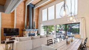 Un vaste espace de vie comprenant un grand canapé, une table à manger en bois et un téléviseur.