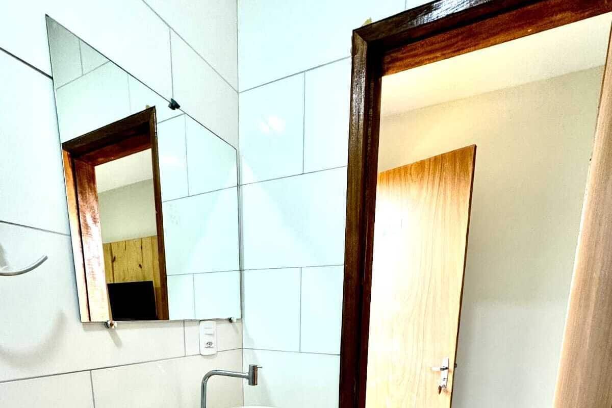 A bathroom with a wooden vanity, a white sink, and a mirror.