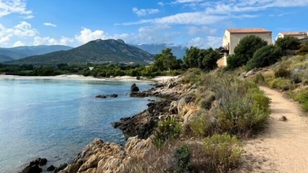 A coastal path with a building on a hillside, overlooking a calm sea and distant mountains. - Villa Lurenzu - Maison pour 8 avec piscine (Belgodère)