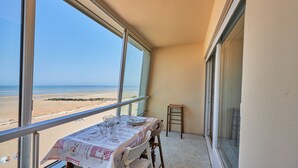 Un balcone con un tavolo apparecchiato per due, vista sulla spiaggia.