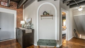 Een moderne keuken met een donker houten aanrecht, een bankje en een witte muur met een plank erboven.