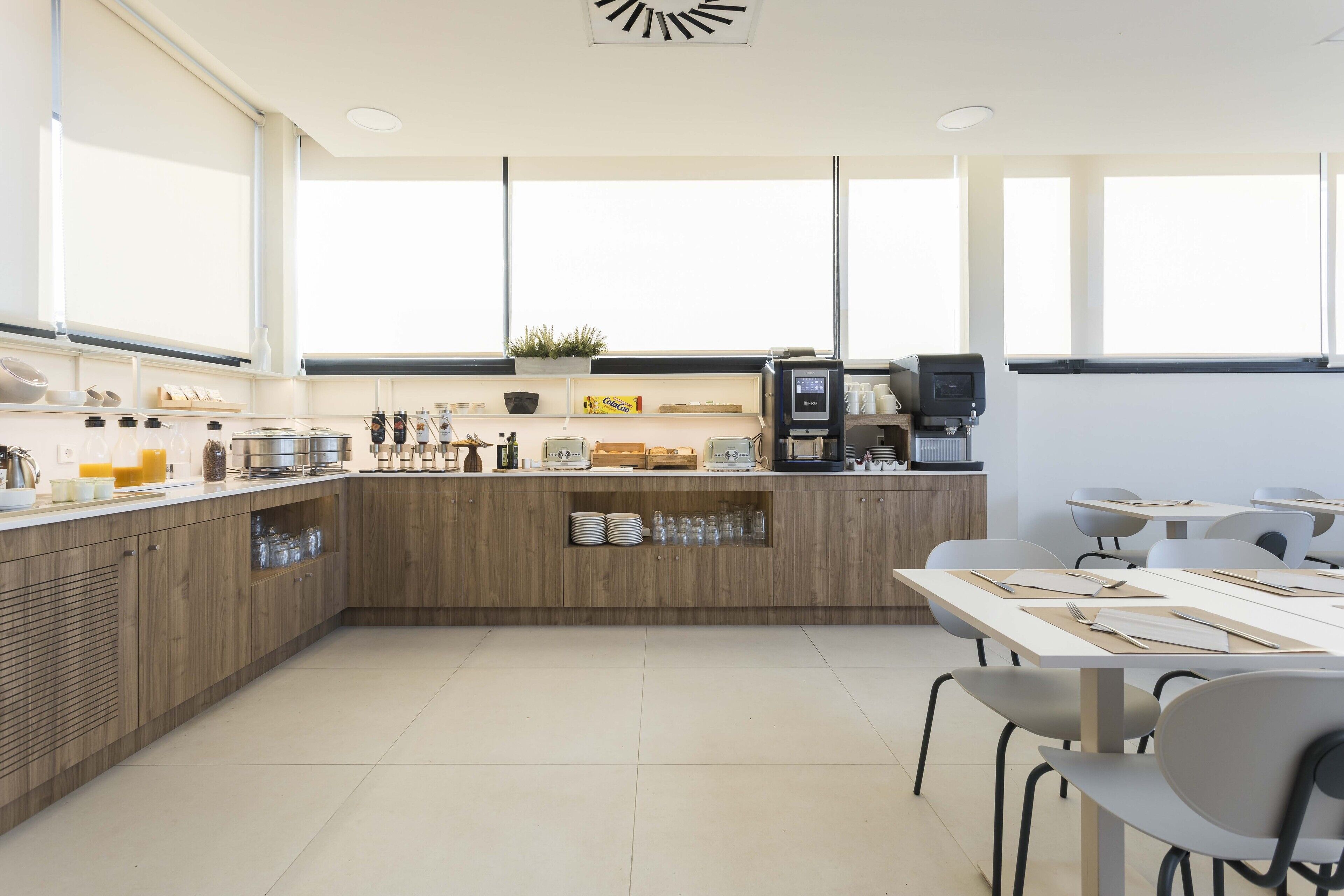 A modern kitchen with wooden cabinets, a coffee machine, and a breakfast bar.