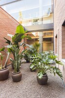 Un patio con plantas en macetas y una pared de ladrillo.