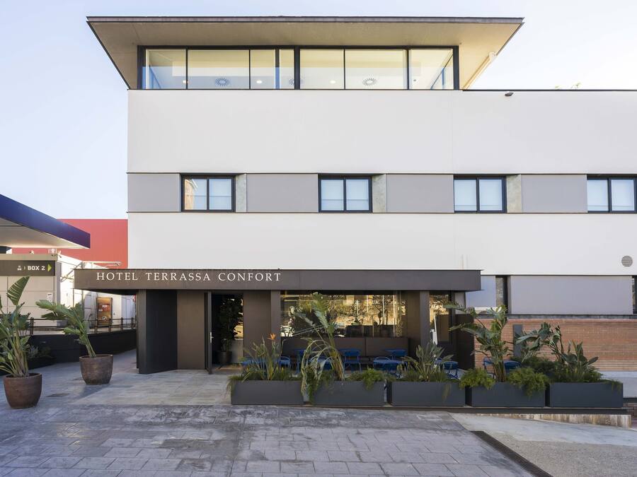 Un hotel moderno con techo plano, ventanas amplias y un cartel que dice "HOTEL TERRASSA CONFORT".