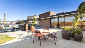 A rooftop terrace with outdoor seating, potted plants, and a view of the cityscape. - Hotel Terrassa Confort (Terrassa)