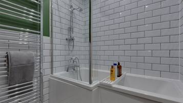 A modern bathroom with a glass-enclosed shower, a white bathtub, and a towel rack.