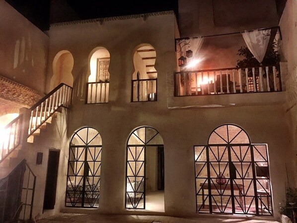 A building with arched windows and a balcony with a railing.