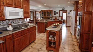 Una cocina amplia con armarios de madera, una isla central y un microondas.