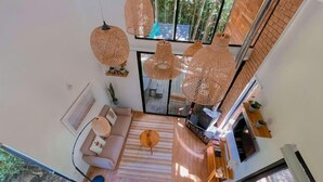 Un salon moderne avec un canapé, une table basse et des lampes suspendues en osier.