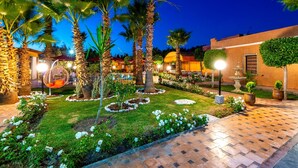 A well-maintained garden with palm trees, a fountain, and a hanging chair. - Villa Gardens Diafa - 8 rooms (Lahebichate)