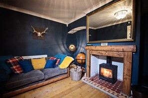 Cozy living room with a fireplace, comfortable sofa, and a globe on a side table.