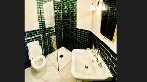 Een badkamer met toilet, wastafel en douche.