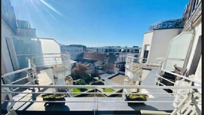 Een balkon met uitzicht op een stadsgezicht, inclusief gebouwen en een heldere lucht.