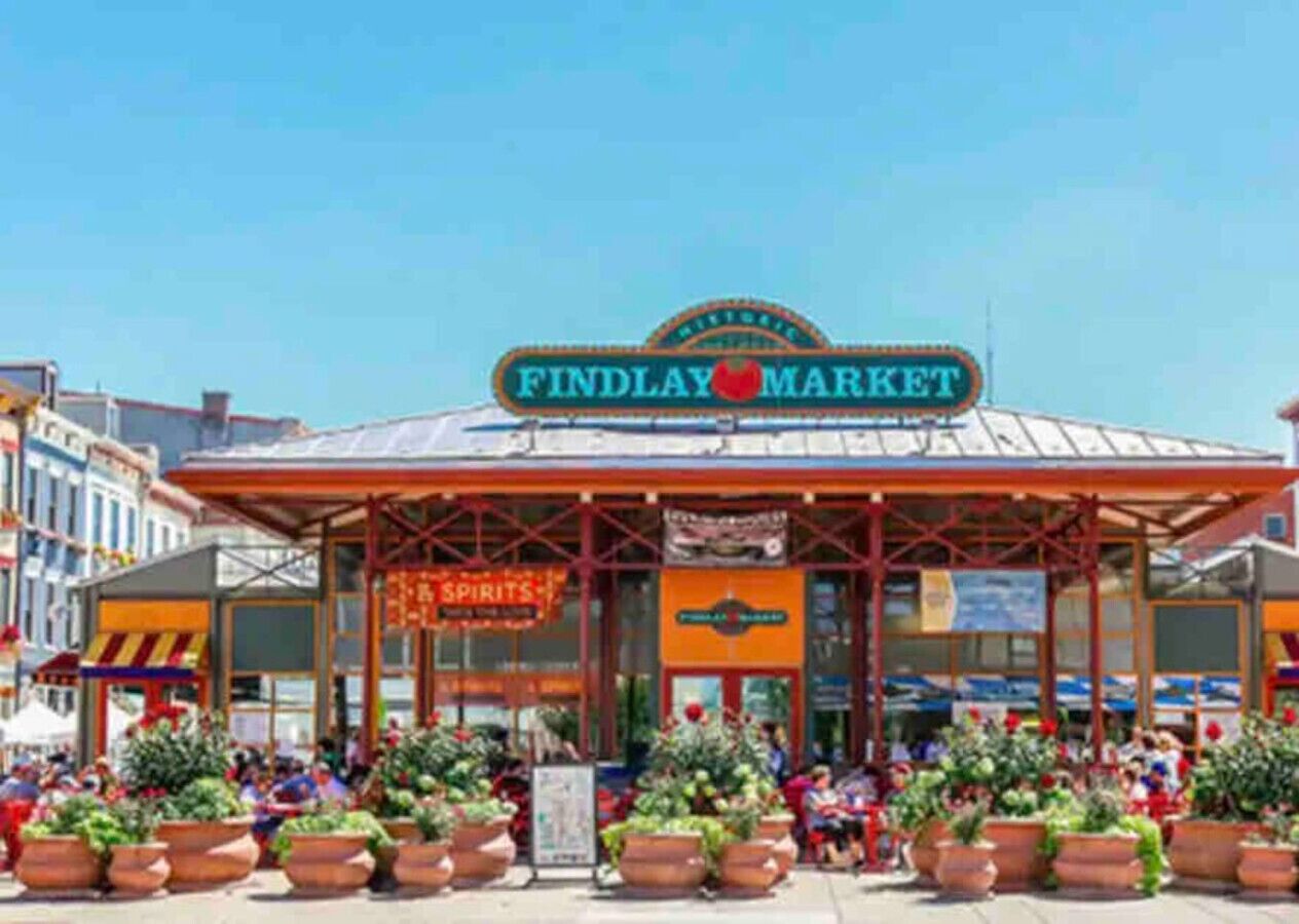 Mercado Findlay con entrada cubierta y plantas en macetas al frente.