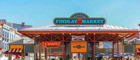 Mercado Findlay con entrada cubierta y plantas en macetas al frente.