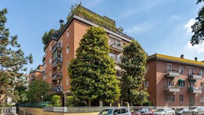 A multi-story residential building with balconies, parked cars, and surrounding greenery. - A Casa di Giorgia by Wonderful Italy (Bologna)