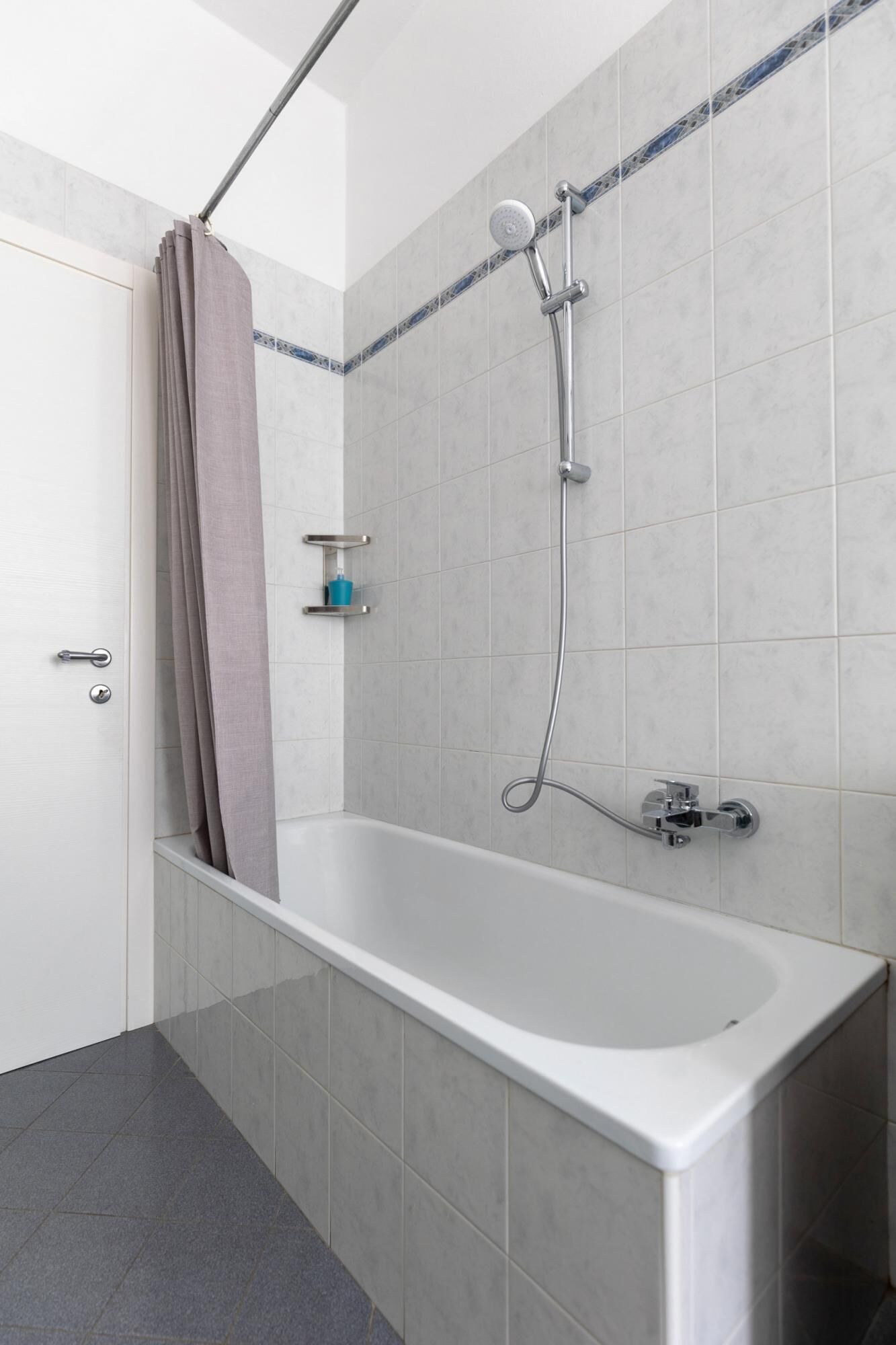 Une salle de bain moderne avec une baignoire sur pieds, une douchette et un porte-serviettes.