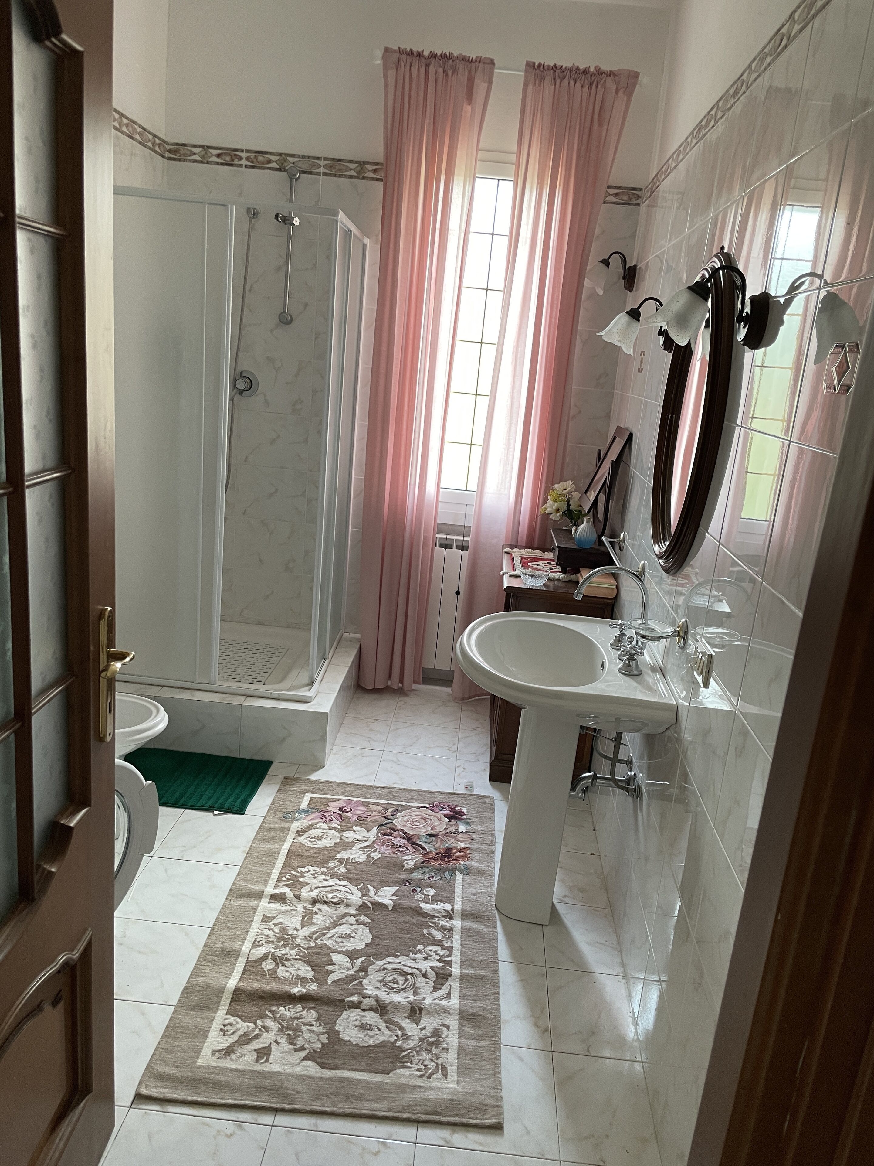 Un bagno con doccia, servizi igienici, lavandino e specchio.