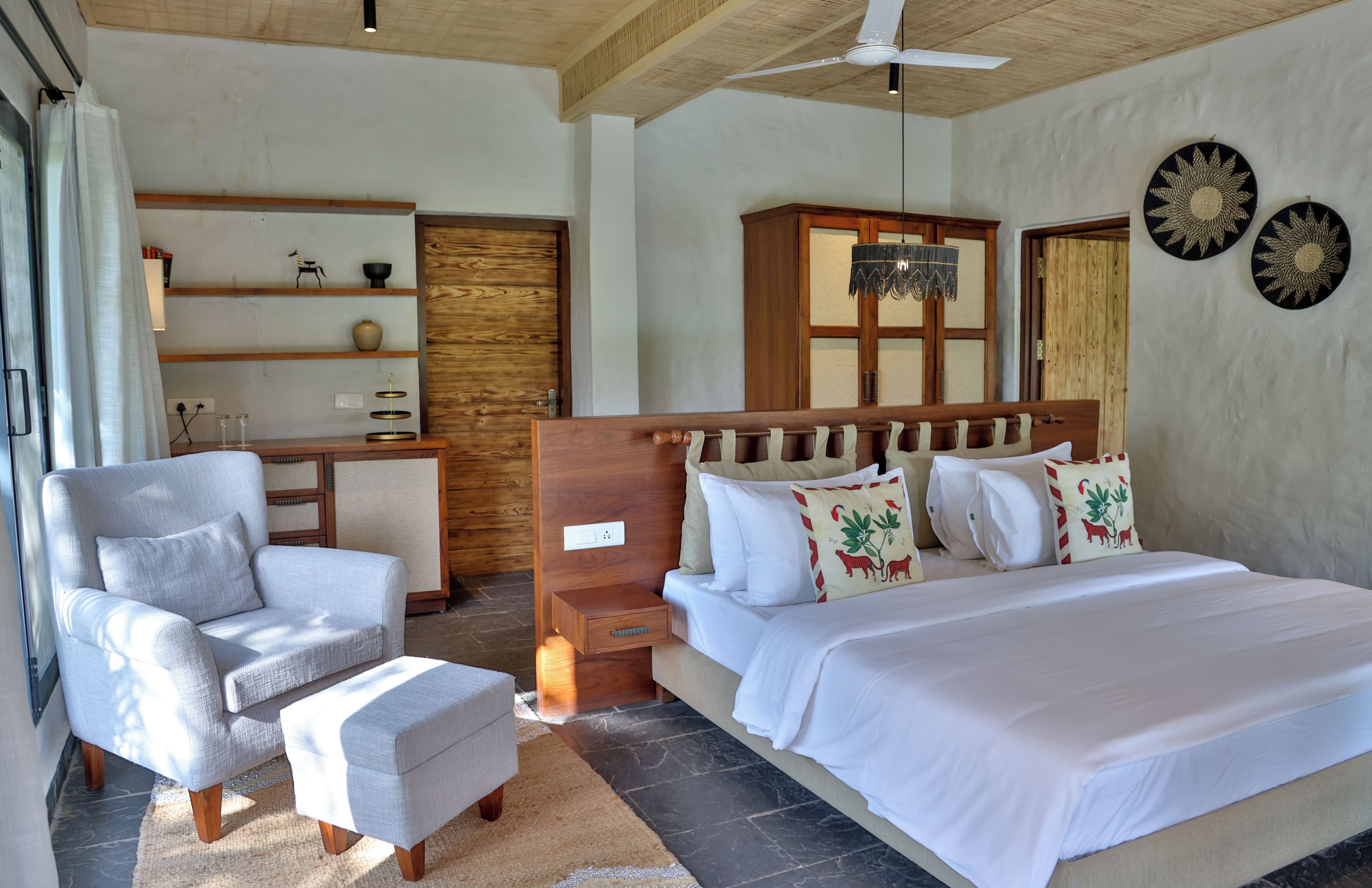 Ein Schlafzimmer mit einem Bett, einem Sessel, einem Schreibtisch und einem Kleiderschrank.
