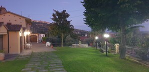 Un patio con una fuente, un sendero empedrado y un edificio con terraza.
