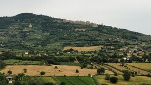 A hilly landscape with scattered buildings and fields.