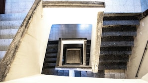 A staircase with a window at the top, leading to a tiled floor. - La Suite del Centro Storico (Naples)