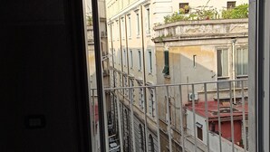 A view from a window overlooking a narrow street with buildings on either side. - La Suite del Centro Storico (Naples)