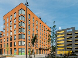 Un edificio de varios pisos con fachada de ladrillo y amplias ventanas.