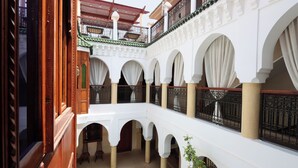 Un pati amb arcs, una piscina i un balcó amb vistes.