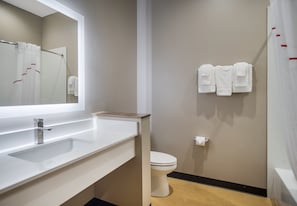 Modern bathroom with a large mirror, white sink, and chrome faucet.