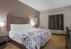 Relax in a stylish room with a large bed, wooden headboard, and desk.