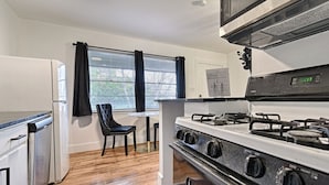 Une cuisine compacte équipée d’un réfrigérateur, d’une cuisinière et d’un coin repas avec une chaise et une table.