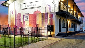 Un immeuble portant l’inscription « CityPlace », doté d’un balcon et affichant un code QR sur son mur.