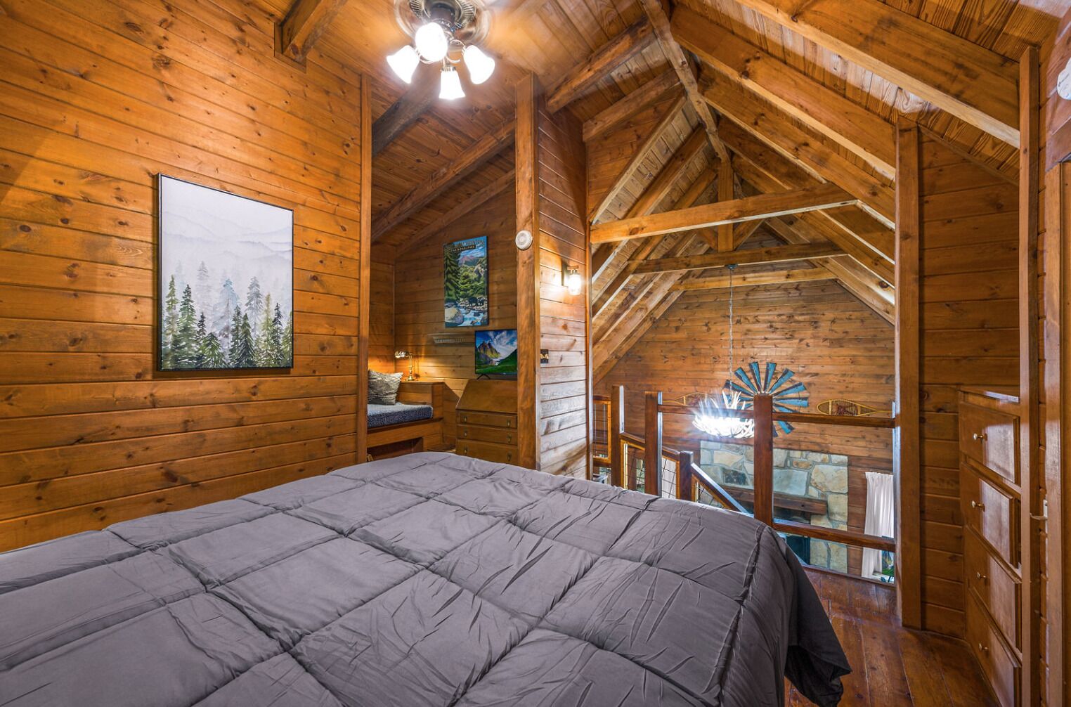 A cozy log cabin bedroom with a bed, a nightstand, and a painting of a forest.
