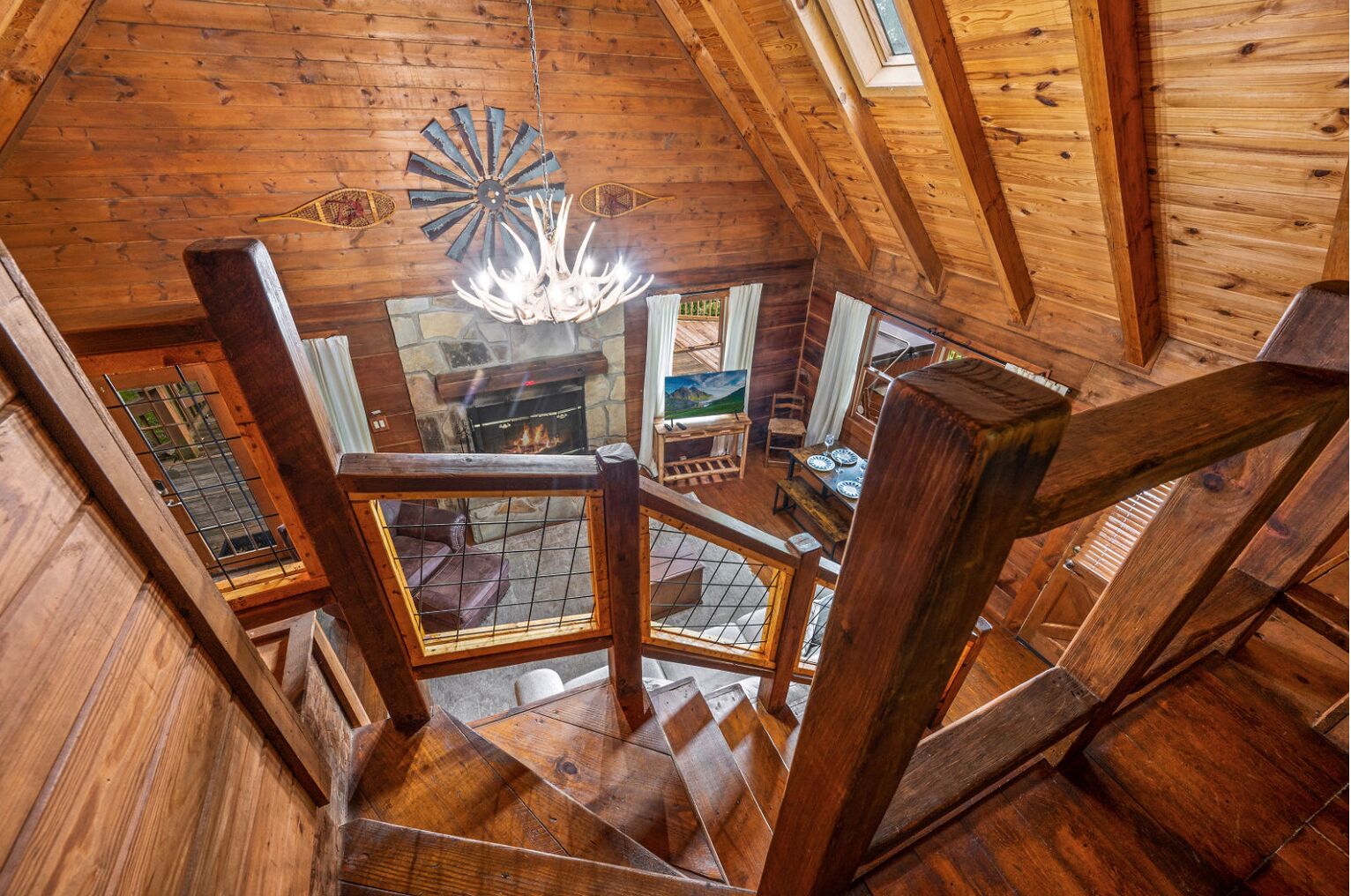 Ein Holzinnenraum mit Wendeltreppe, Kamin und einer Chandelier.