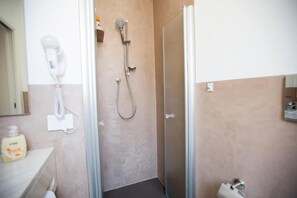 Een douche, een haardroger, een bidet, handdoeken