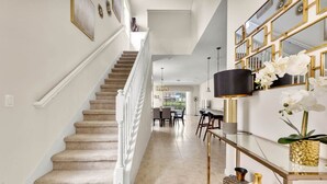 A staircase leading to a dining area with a modern interior.