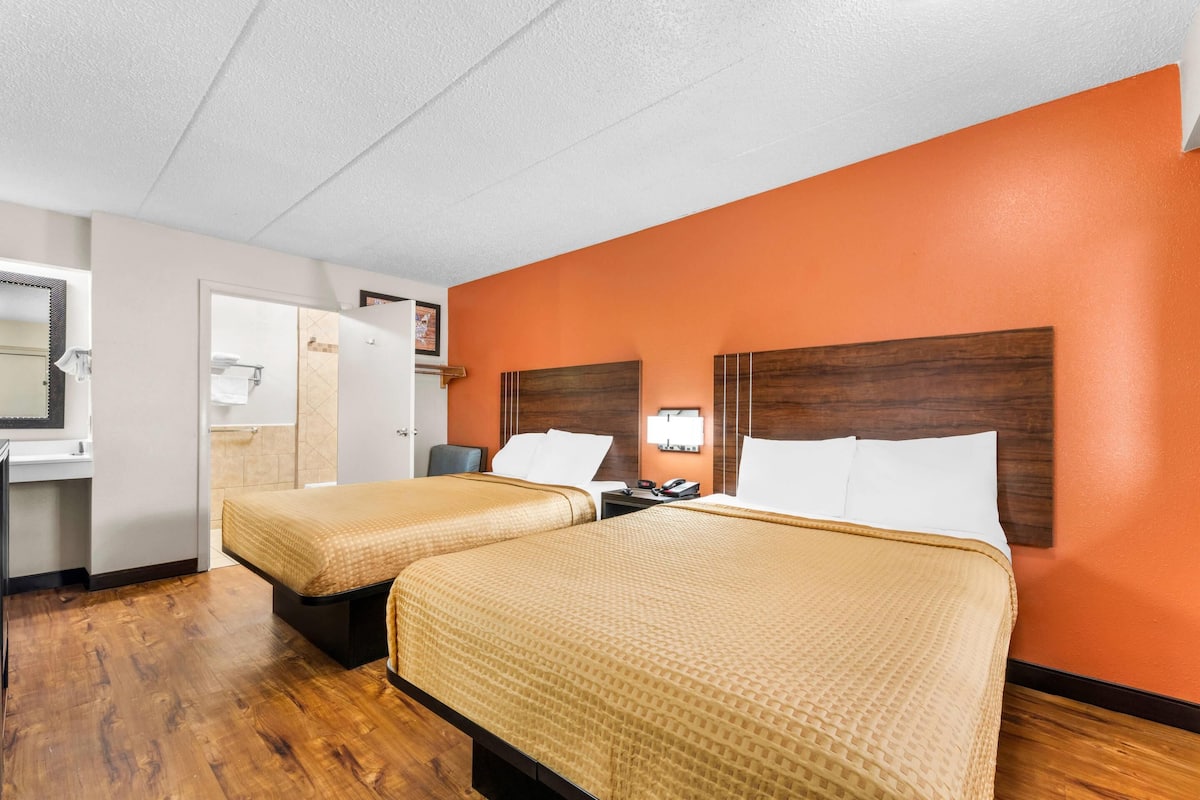 Une chambre d’hôtel avec deux lits, une salle de bain et un bureau.