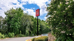 Une enseigne indiquant l’emplacement d’un hôtel Econo Lodge, avec un espace de stationnement et de la verdure aux alentours.