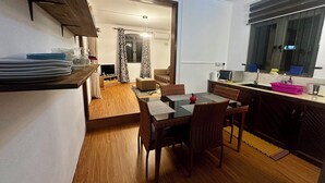A compact living space with a dining area, kitchenette, and a small seating area.