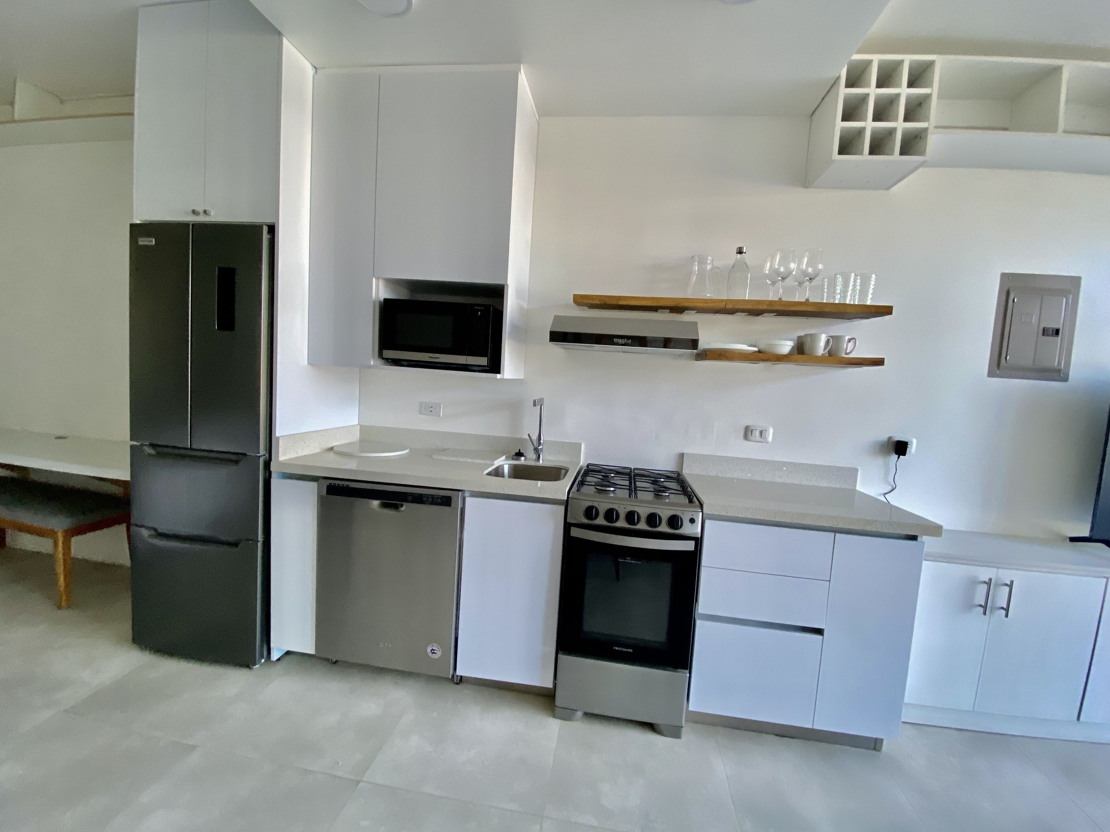 A modern kitchen with a built-in refrigerator, dishwasher, stove, and microwave.