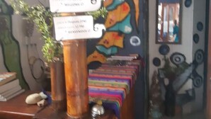 Una recepción con un mural colorido en la pared, una planta y un cartel con texto.