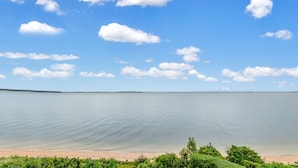 Ein ruhiger See mit klarem Himmel und vereinzelten Wolken.