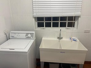A laundry area with a washing machine and a sink.