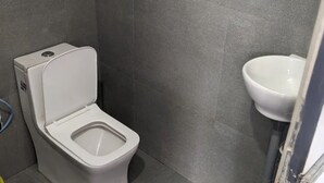Un baño moderno con inodoro y lavamanos blancos.